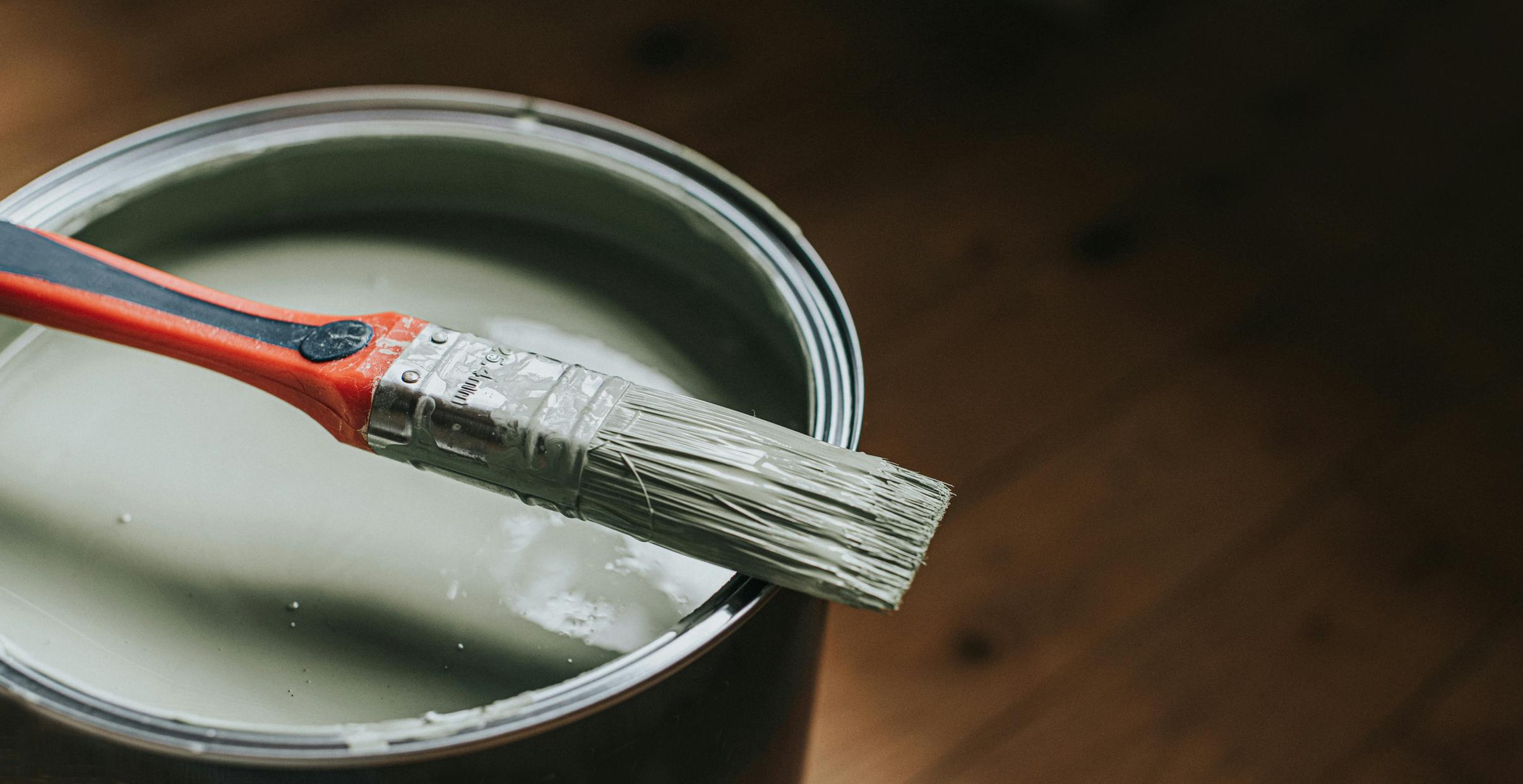 open pot of paint with brush on top